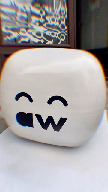 A 3D-printed white cube with a smiling face