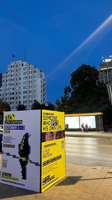 SFK 11th edition posters on a street in Prishtinë at night